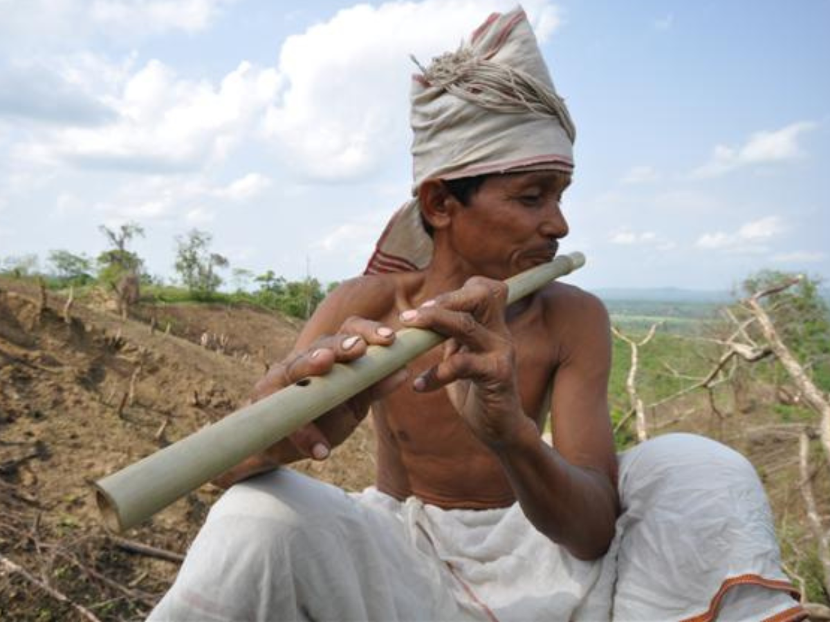 Tripuri man playing Bamboo flute Tripuri man playing Bamboo flute